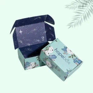 A beautifully designed mailer box adorned with a blue (teal) and white floral pattern, ideal for eye-catching packaging.