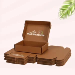 A stack of flattened brown mailer boxes with one box assembled and open on top. A custom logo is printed on the assembled box.