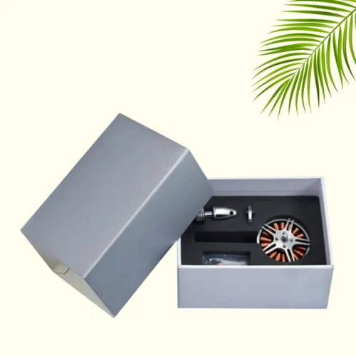 A simple, high-end gray packaging box for drone parts, with a detachable lid. The open box reveals custom black foam inserts holding a motor, propeller, and other small accessories.