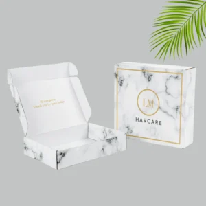 A luxury marble mailer boxes with gold accents. The outer box features the logo in a gold circle design.
