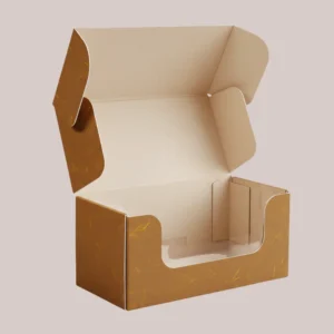 An open brown mailer box with a cutout window on the front, featuring a rustic paper texture with golden flecks, designed for wholesale cookie packaging.