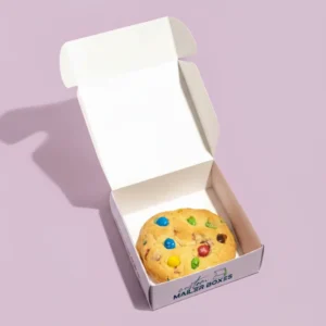 White inside and pink outside coloured single cookie mailer box, shown open to reveal a single M&M cookie, with custom branding text on the bottom, perfect for individual treats.