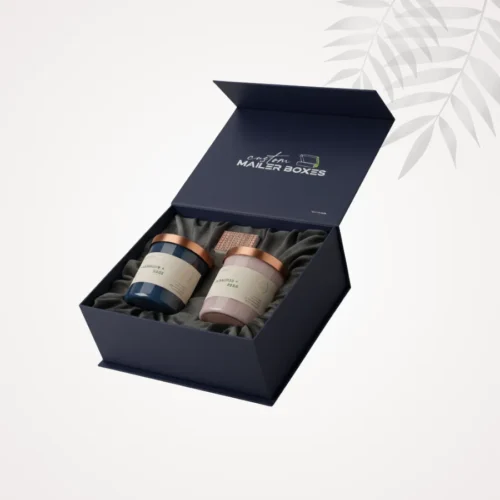 Open navy blue magnetic closure rigid box with two luxury jar candles and velvet-like fabric interior for high-end gift packaging.