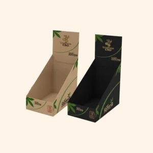 Two cardboard retail display boxes for 'BeeBee CBD' products; one natural kraft brown and one black, both featuring green leaf accents and the '300mg' label.