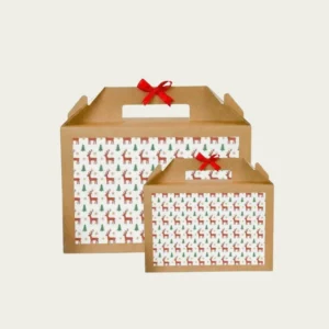 Two sizes of kraft brown holiday packaging boxes with carry handles, decorated with a red and green repeating pattern of reindeer and Christmas trees, tied with a small red bow.