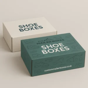 Two rectangular shoe boxes, one closed and dark green with white text, and one simple white box behind it, used for custom shoe packaging.